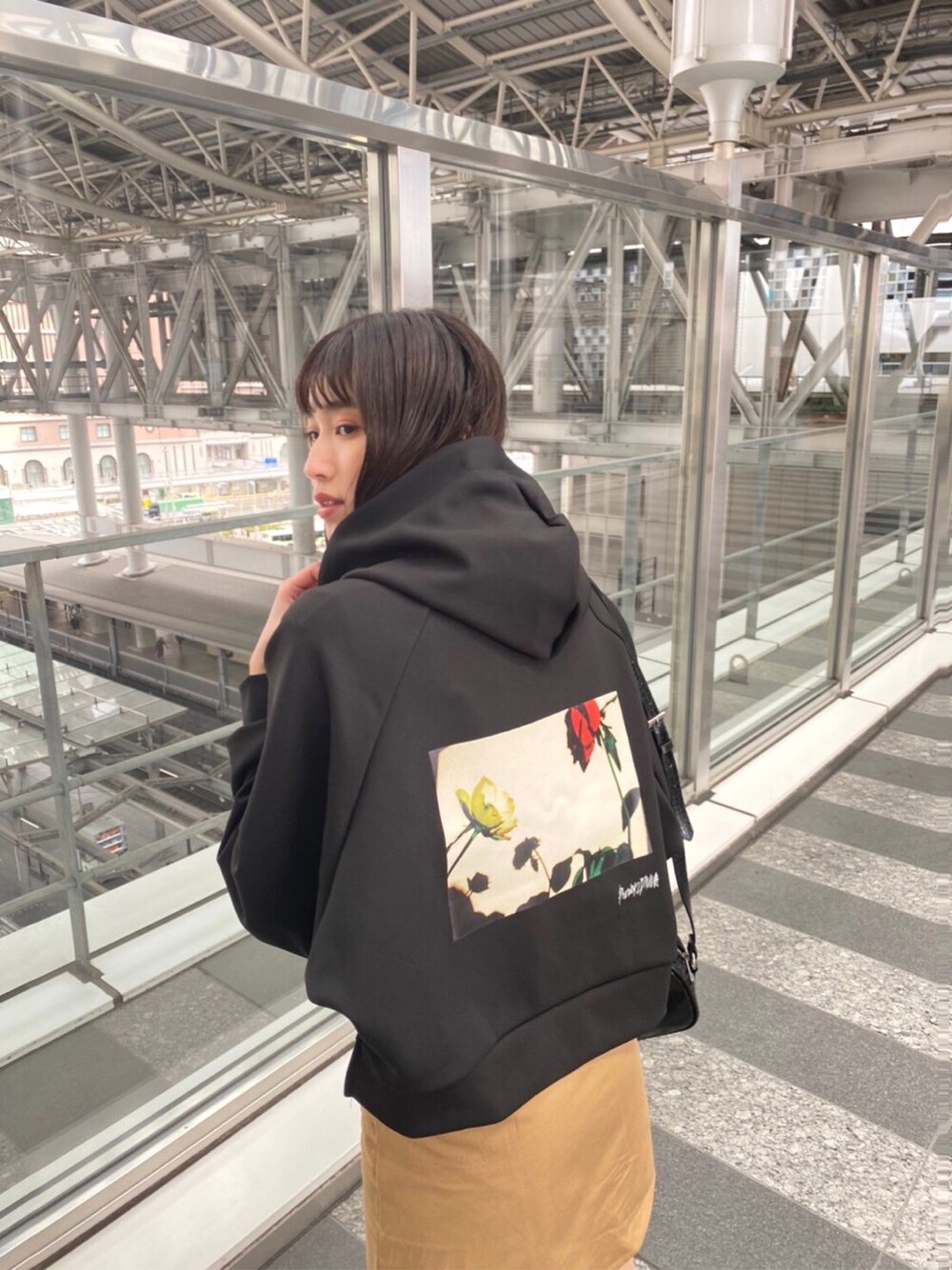 ベージュ系のトレンチコート、ベージュ系のスカート、ブラック系のブーツを着用したレディースの冬コーディネートの2枚目の写真