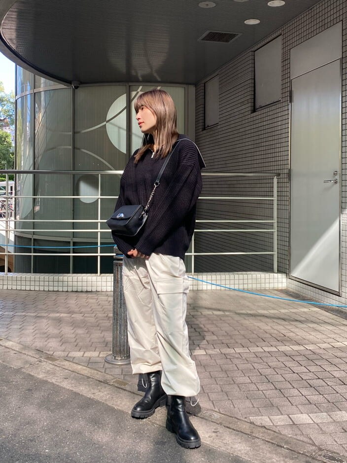 ブラック系のブーツ、ブラック系のニット/セーター、ブラック系のショルダーバッグを着用したレディースの秋コーディネートの2枚目の写真