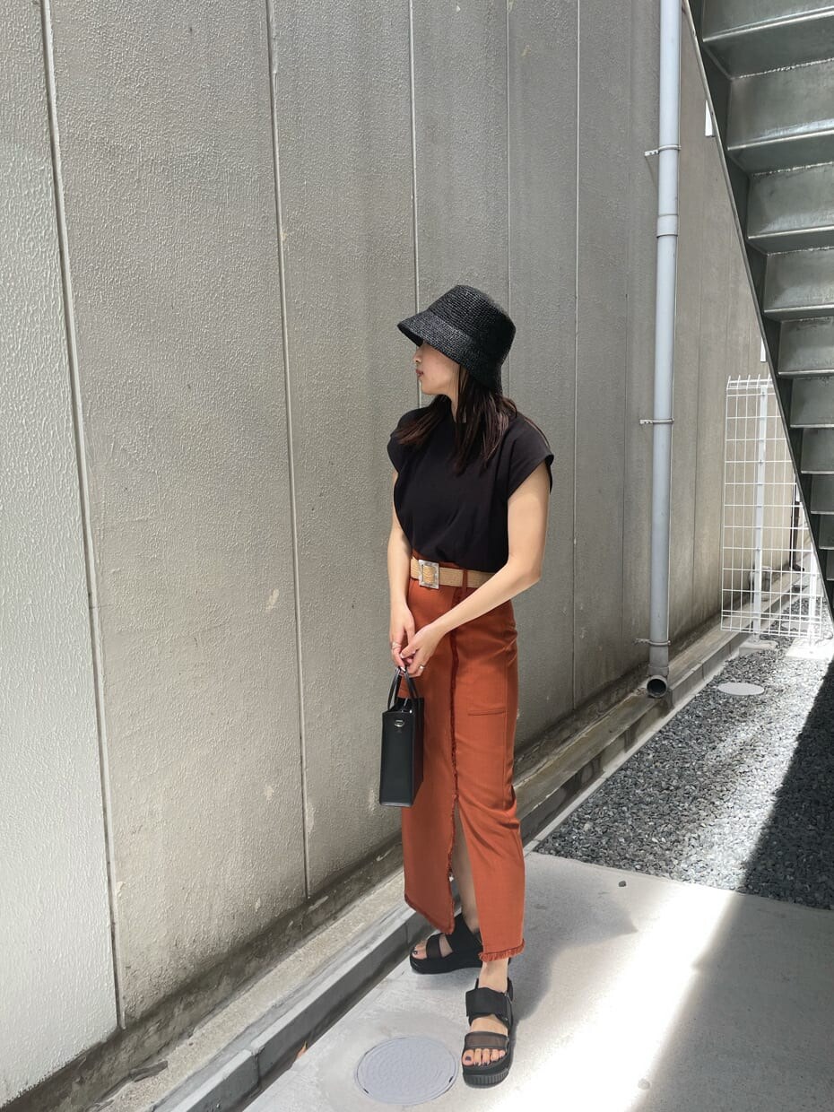 ブラック系のサンダル、オレンジ系のスカート、ブラック系のタンクトップを着用したレディースの夏コーディネートの2枚目の写真