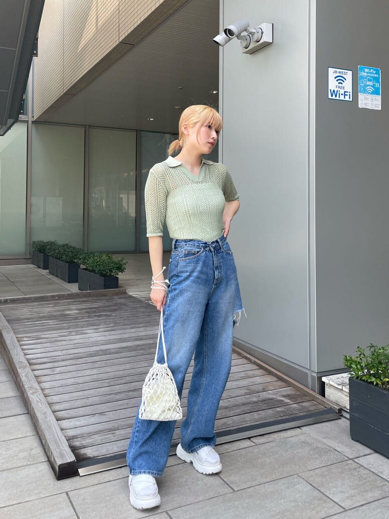 ホワイト系のサンダル、ホワイト系のハンドバッグ、グリーン系のポロシャツを着用したレディースの春コーディネートの2枚目の写真