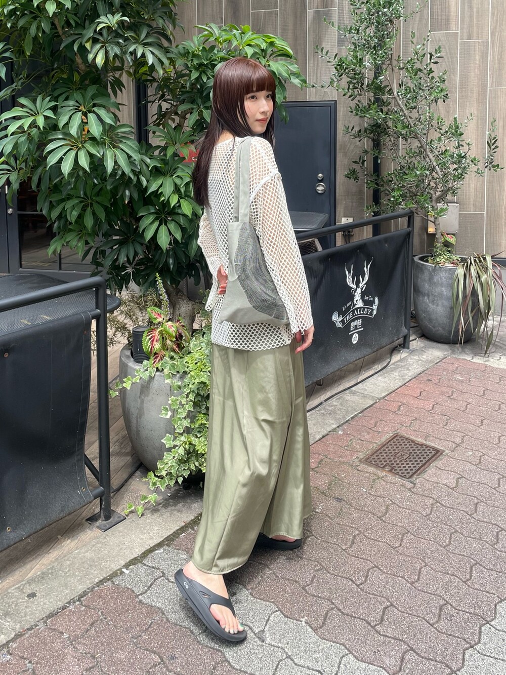 グリーン系のワンピース、ホワイト系のシャツ/ブラウスを着用したレディースの夏コーディネートの2枚目の写真