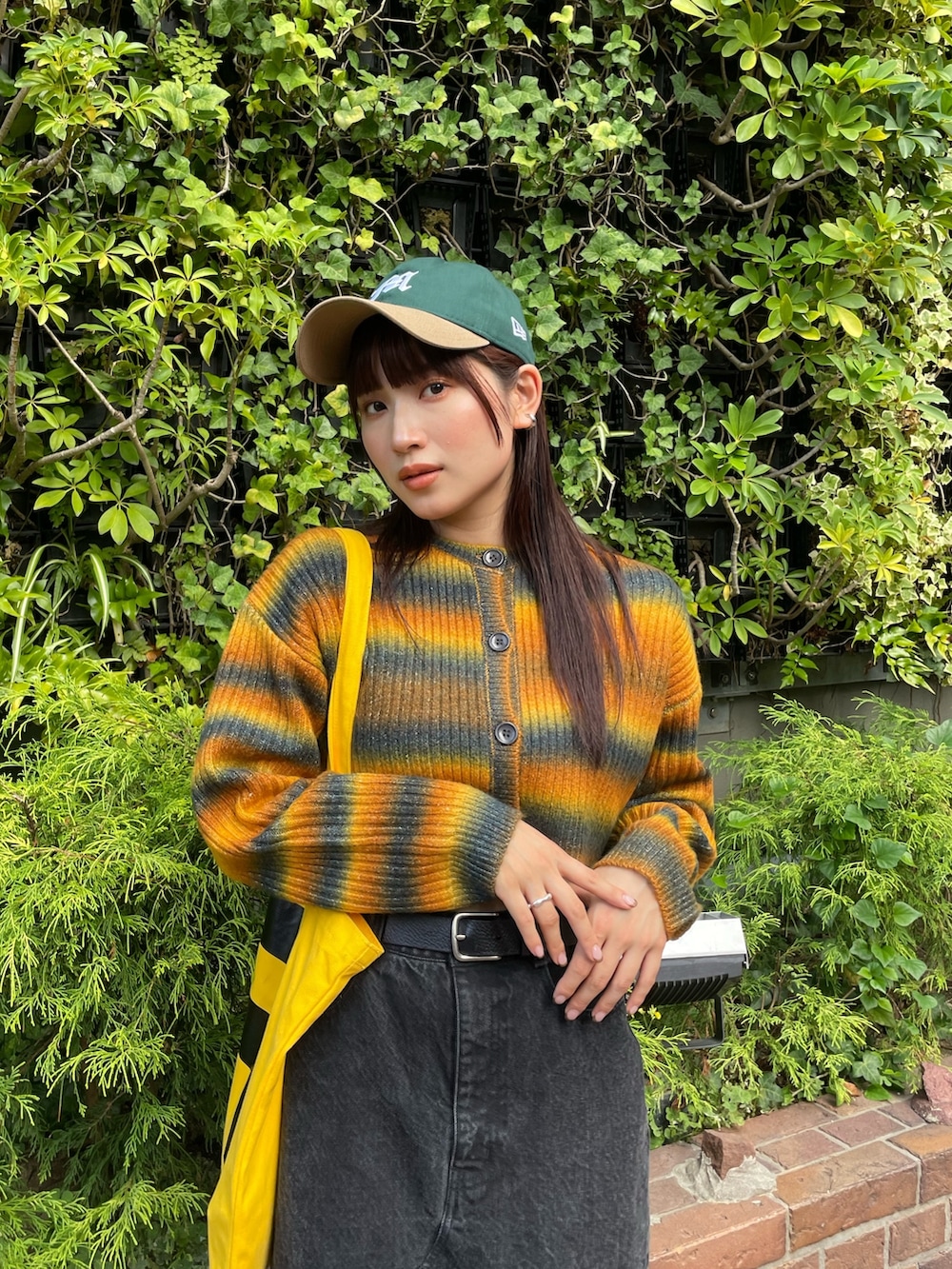 イエロー系のカーディガン/ボレロ、グリーン系のキャップを着用したレディースの秋コーディネートの3枚目の写真
