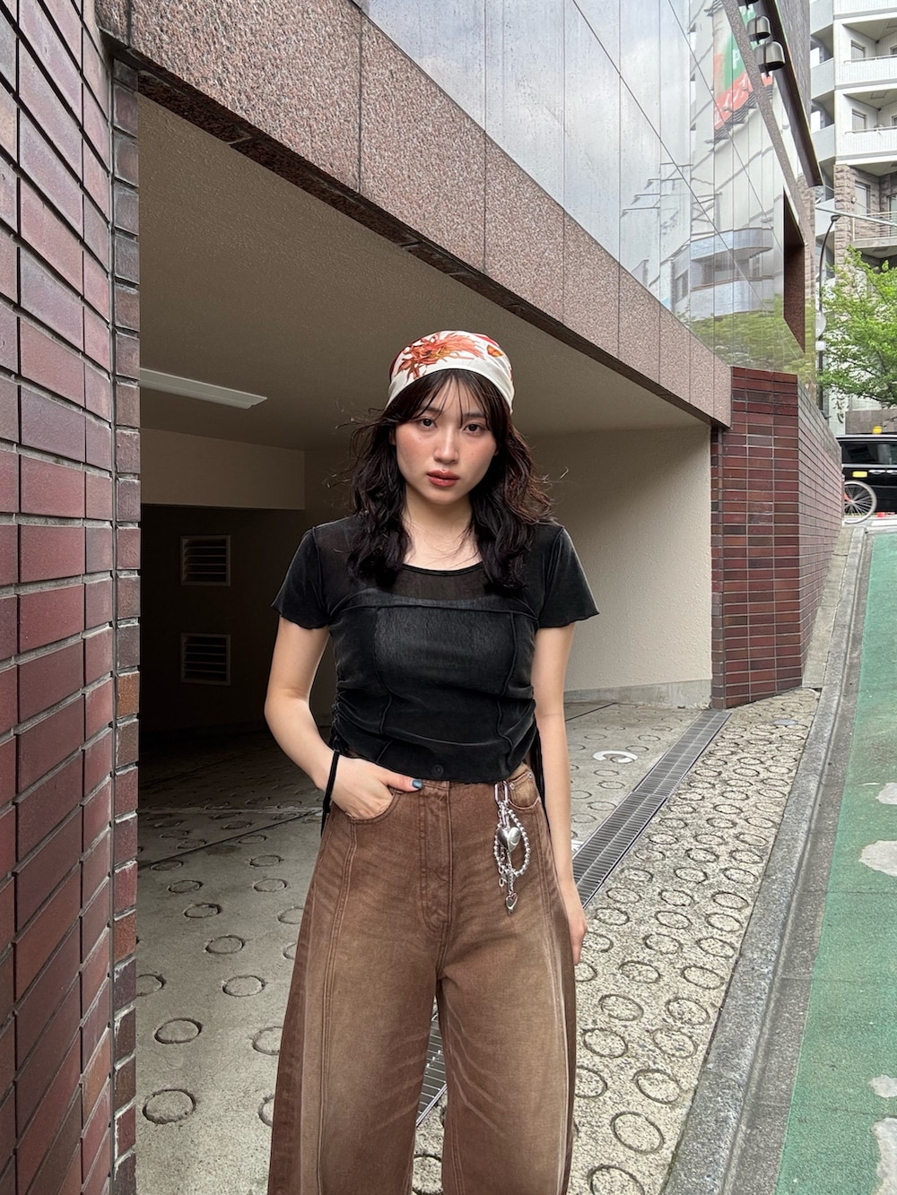 ブラック系のサンダル、ブラウン系のデニムパンツ、ブラック系のTシャツ/カットソーを着用したレディースの春コーディネートの3枚目の写真