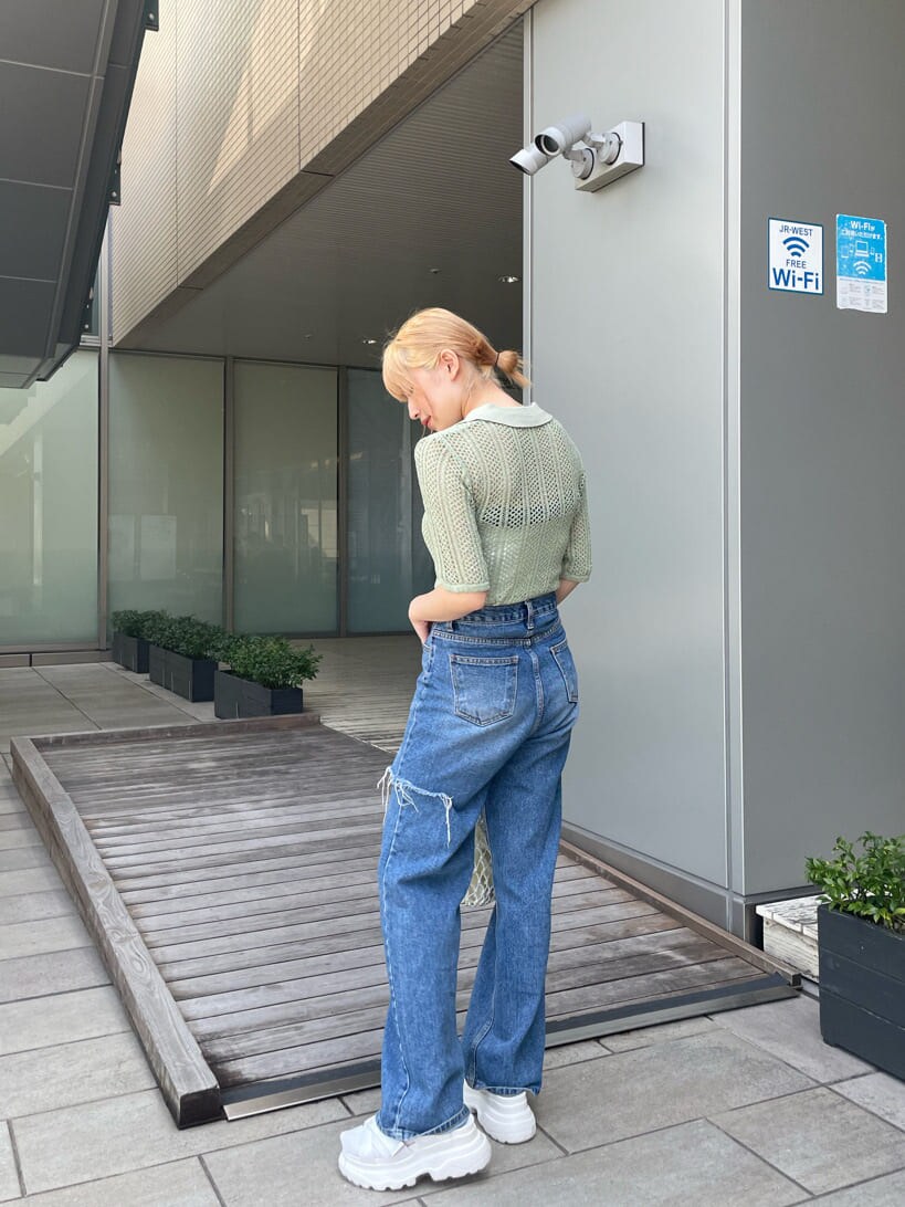 ホワイト系のサンダル、ホワイト系のハンドバッグ、グリーン系のポロシャツを着用したレディースの春コーディネートの3枚目の写真