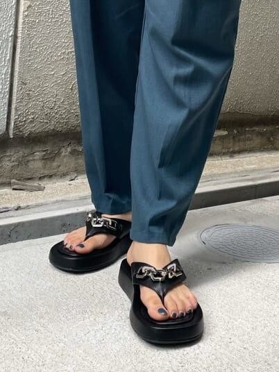 グリーン系のスラックス、ブラック系のサンダル、ホワイト系のTシャツ/カットソーを着用したレディースの夏コーディネートの7枚目の写真