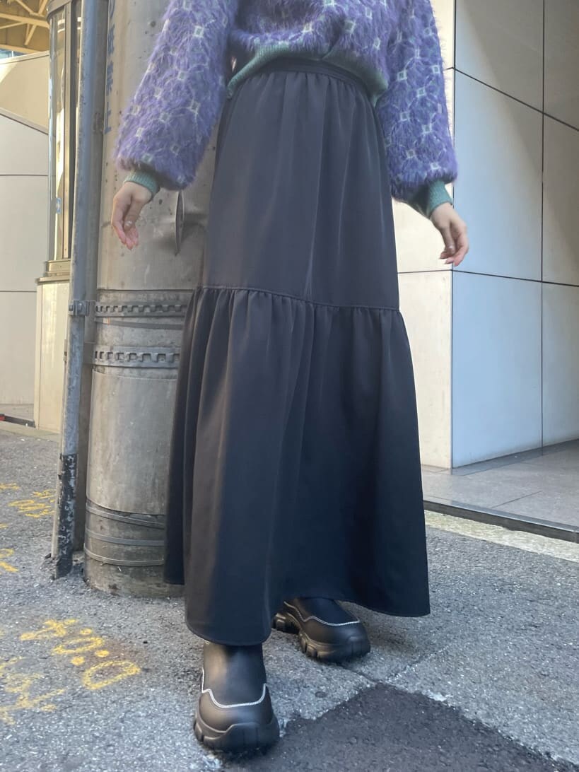 ブラック系のブーツ、ブラック系のスカート、パープル系のニット/セーターを着用したレディースの秋コーディネートの6枚目の写真