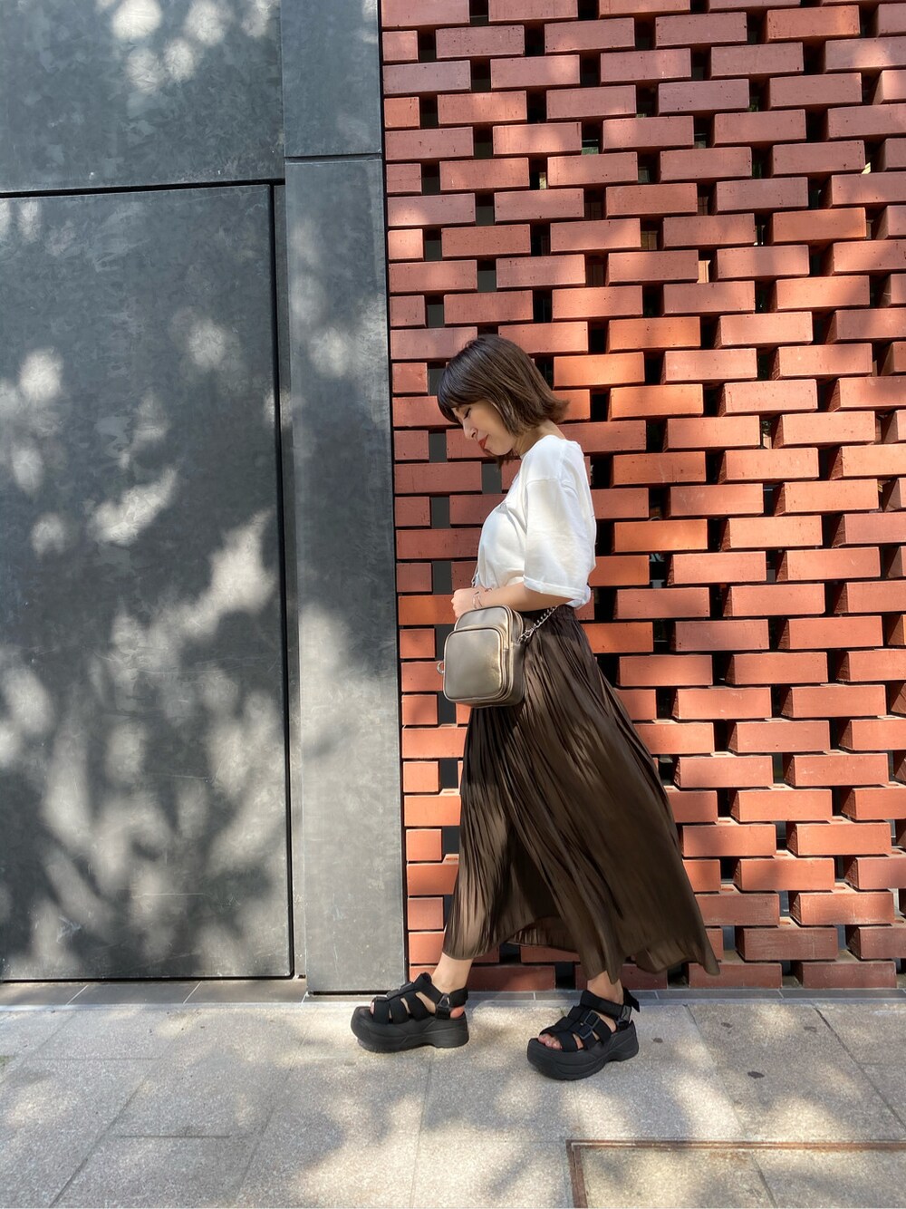 ホワイト系のTシャツ/カットソー、ブラウン系のスカート、ブラック系のサンダルを着用したレディースの夏コーディネートの3枚目の写真