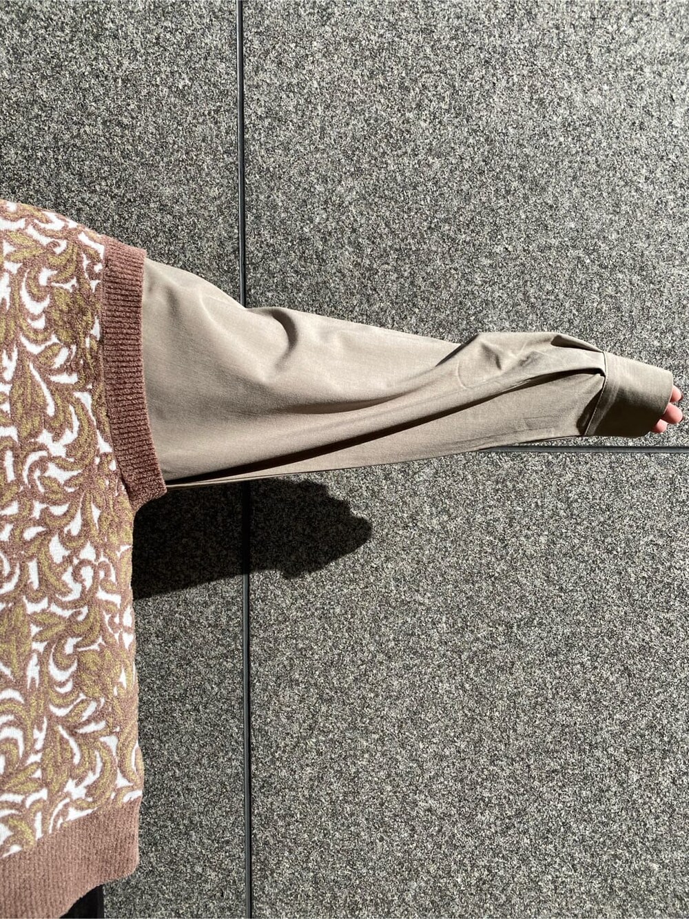 ブラック系のスラックス、ベージュ系のチェスターコート、ブラック系のブーツを着用したレディースの秋コーディネートの9枚目の写真