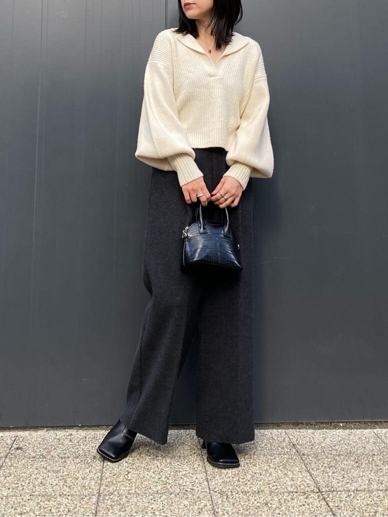 ブラック系のハンドバッグ、グレー系のその他パンツ、ブラック系のブーツを着用したレディースの秋コーディネートの2枚目の写真