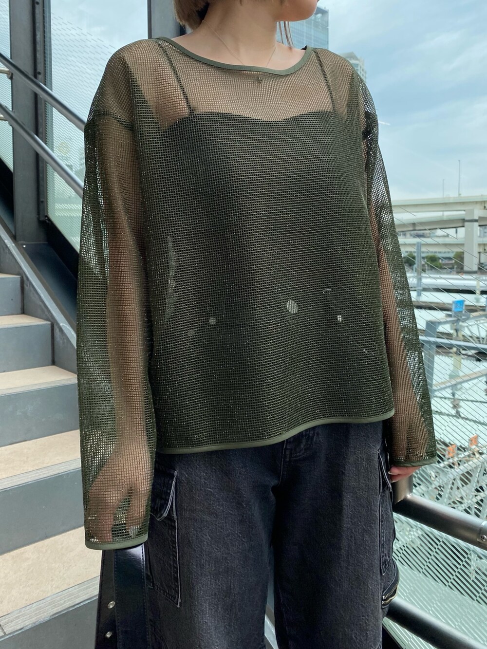 グリーン系のTシャツ/カットソー、ブラック系のデニムパンツ、ブラック系のショルダーバッグを着用したレディースの冬コーディネートの5枚目の写真
