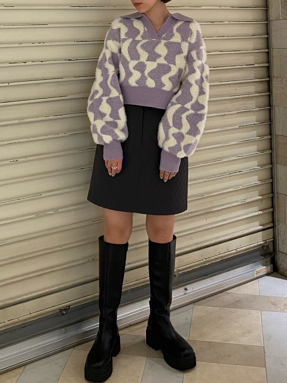 パープル系のニット/セーター、グレー系のスカート、ブラック系のブーツを着用したレディースの秋コーディネートの4枚目の写真