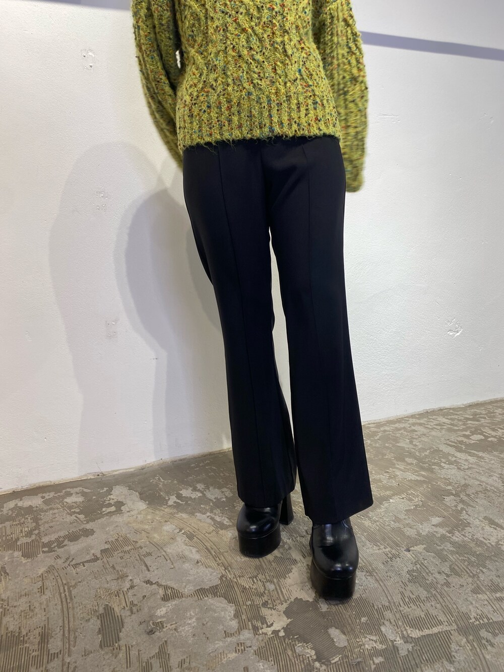 グリーン系のニット/セーター、ブラック系のスウェットパンツ、ブラック系のブーツを着用したレディースの冬コーディネートの7枚目の写真