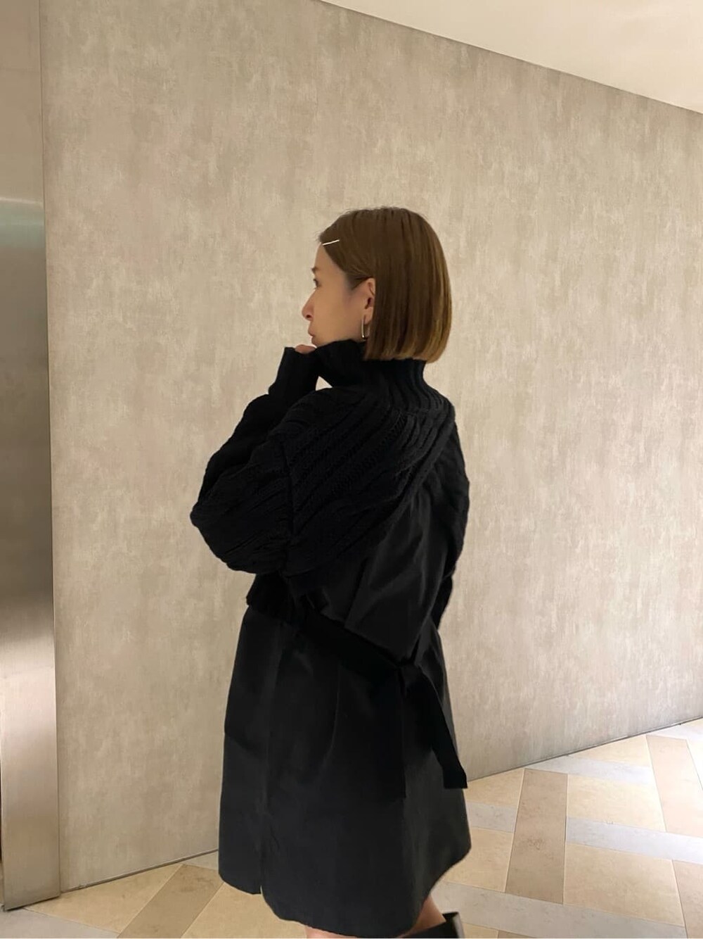 ブラック系のワンピース、ブラック系のブーツ、グレー系のハットを着用したレディースの秋コーディネートの6枚目の写真