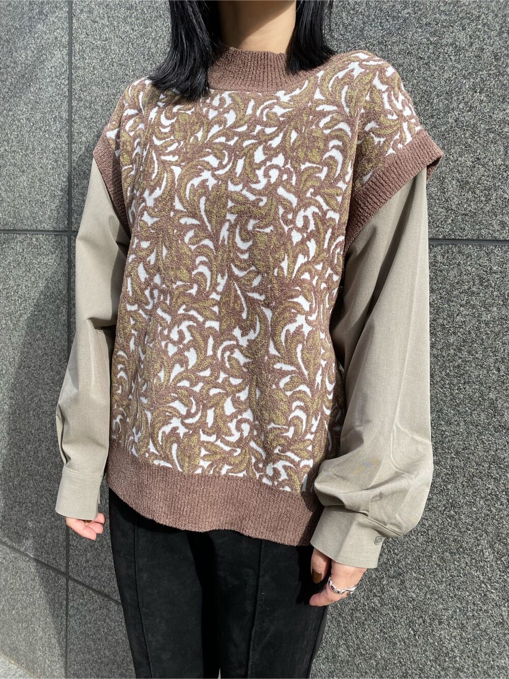 ブラック系のスラックス、ベージュ系のチェスターコート、ブラック系のブーツを着用したレディースの秋コーディネートの8枚目の写真