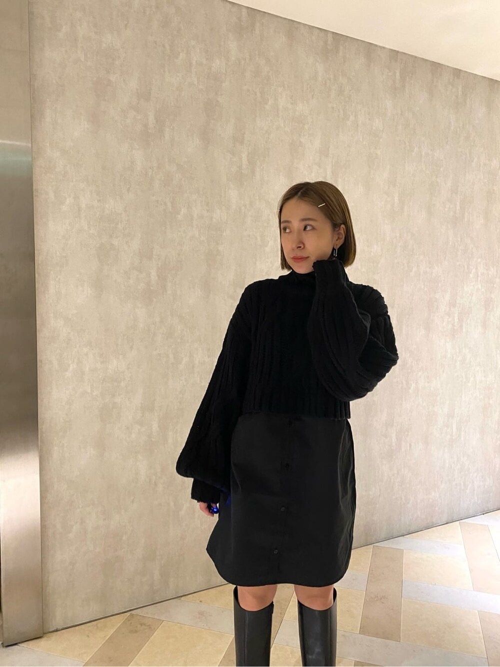 ブラック系のワンピース、ブラック系のブーツ、グレー系のハットを着用したレディースの秋コーディネートの7枚目の写真