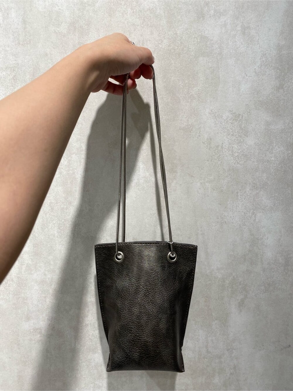 ブラック系のショルダーバッグ、その他のサンダル、グレー系のTシャツ/カットソーを着用したレディースの春コーディネートの9枚目の写真