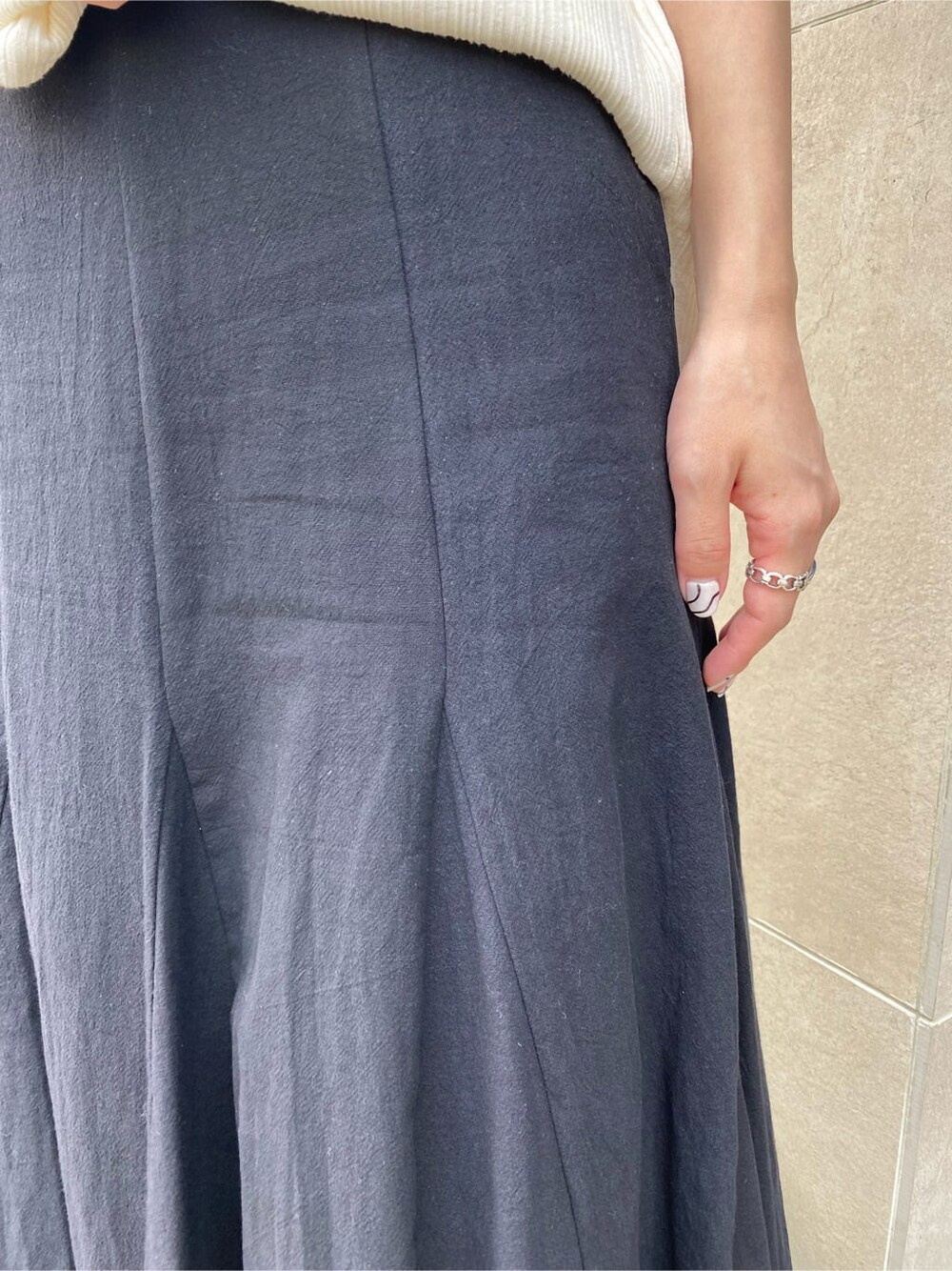 ブラック系のスカート、ブラック系のサンダル、ホワイト系のTシャツ/カットソーを着用したレディースの夏コーディネートの5枚目の写真