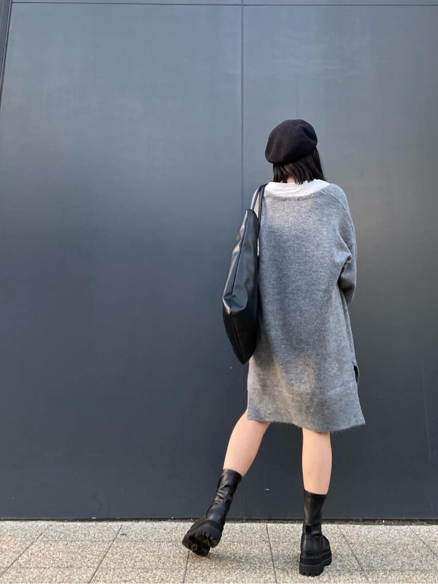 ホワイト系のTシャツ/カットソー、グレー系のニット/セーター、ブラック系のブーツを着用したレディースの秋コーディネートの2枚目の写真