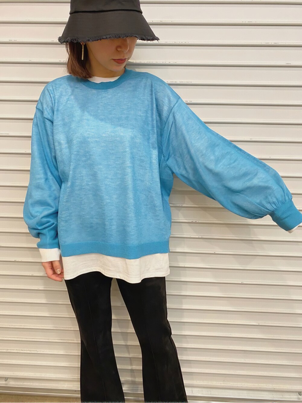 ブラック系のその他パンツ、ブルー系のニット/セーター、ブラック系のハットを着用したレディースの春コーディネートの4枚目の写真