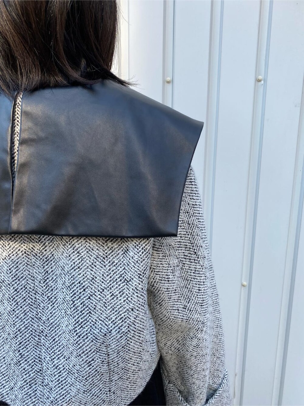 ブラック系のワンピース、ホワイト系のブルゾン、ブラック系のブーツを着用したレディースの秋コーディネートの8枚目の写真