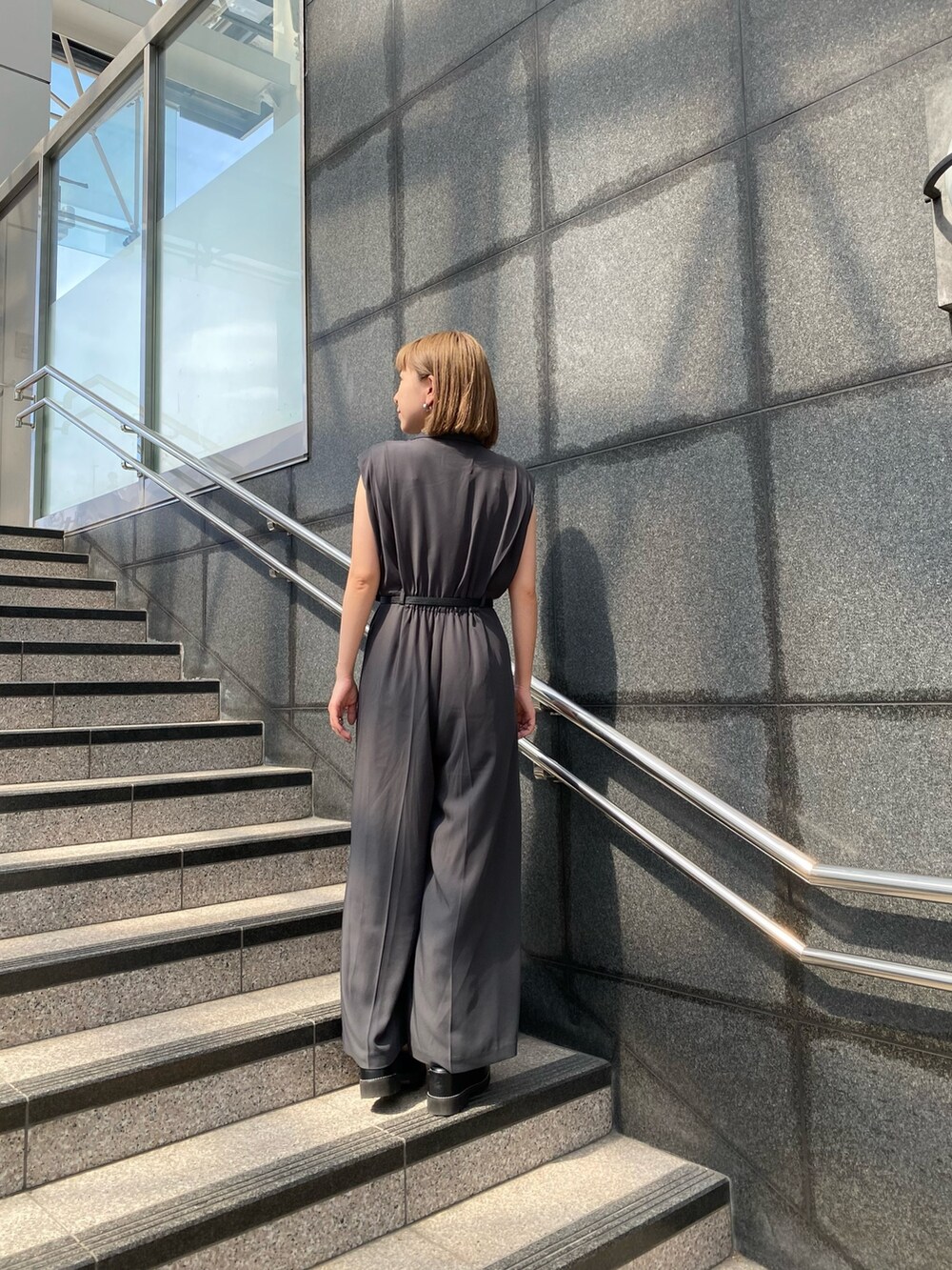 グレー系のつなぎ/オールインワン、ブラック系のサンダルを着用したレディースの春コーディネートの2枚目の写真