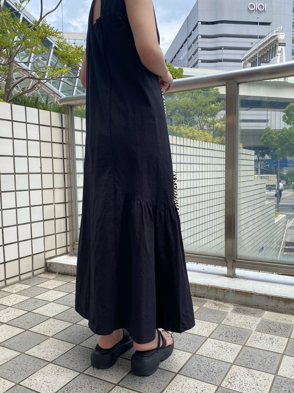 ブラック系のワンピース、その他のトートバッグ、ブラック系のサンダルを着用したレディースの夏コーディネートの3枚目の写真