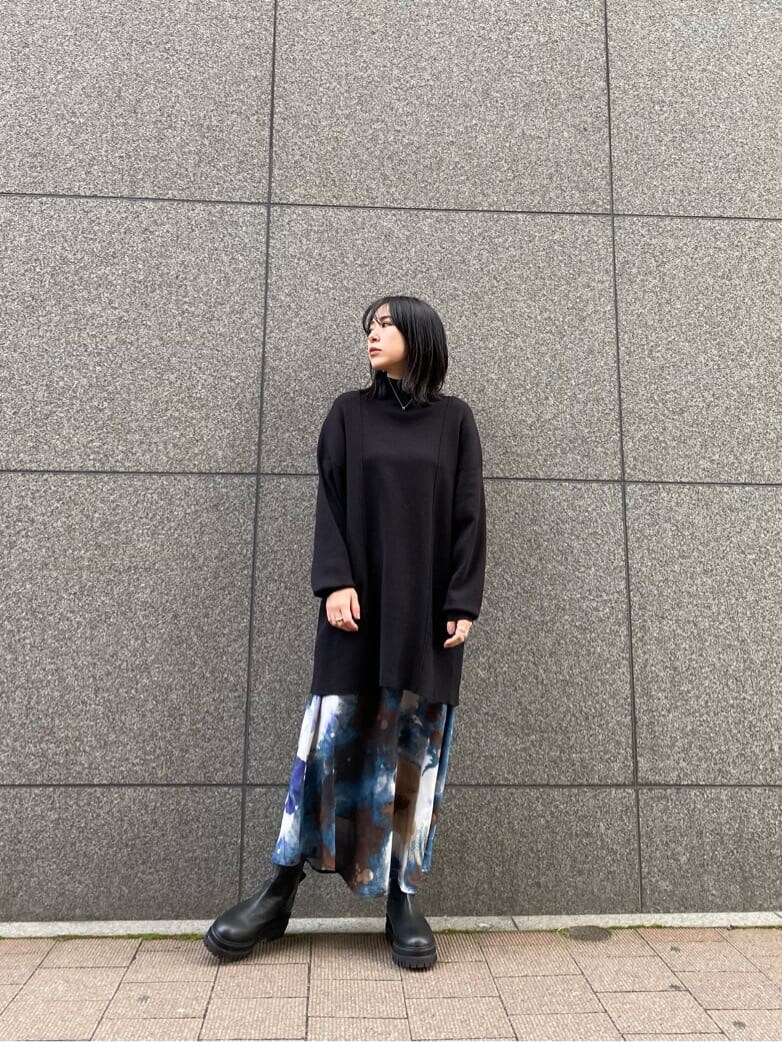 ブラック系のワンピース、ブルー系のスカート、ブラック系のブーツを着用したレディースの秋コーディネートの2枚目の写真