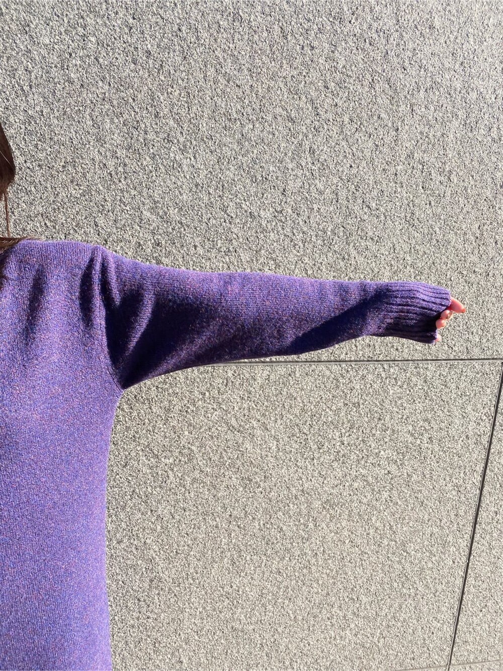 ブラック系のハンドバッグ、パープル系のワンピース、ブラック系のブーツを着用したレディースの冬コーディネートの8枚目の写真