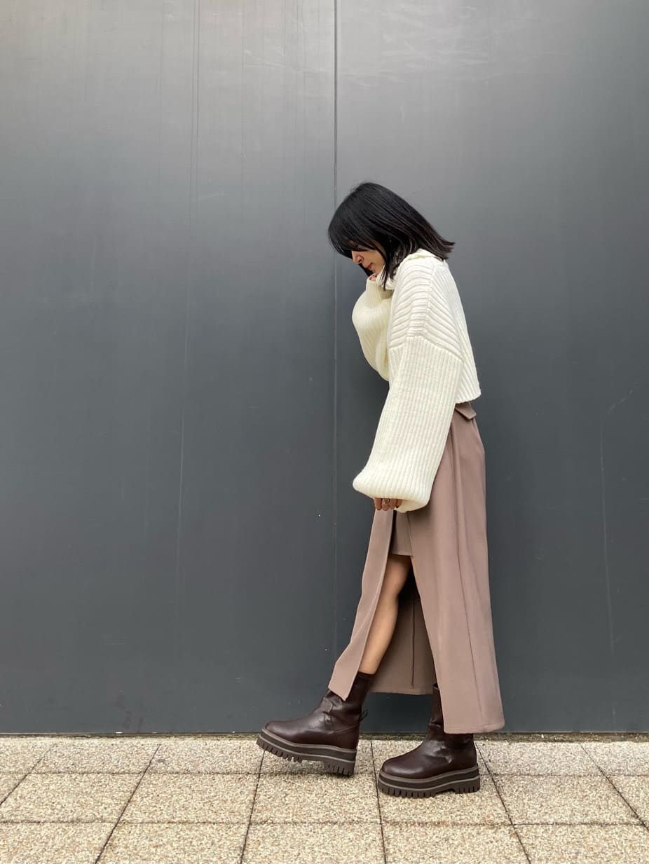 ベージュ系のスカート、ホワイト系のブルゾン、ブラウン系のブーツを着用したレディースの冬コーディネートの6枚目の写真