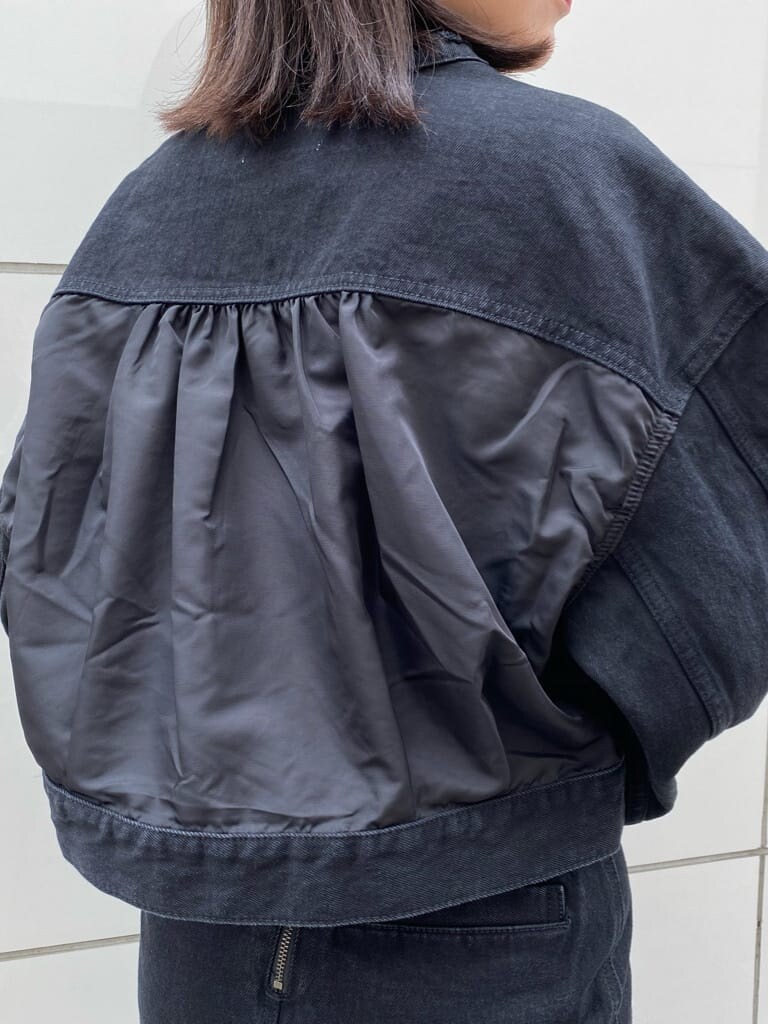 ブラック系のスカート、ブラック系のパンプス、ブラック系のブルゾンを着用したレディースの夏コーディネートの4枚目の写真