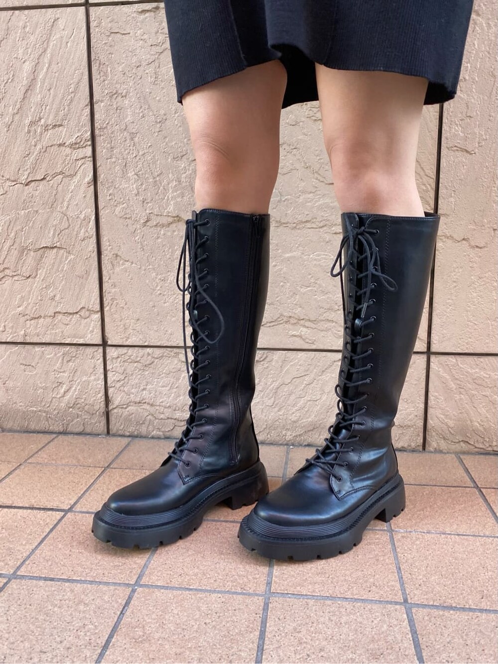 ブラック系のワンピース、ブラック系のダウンジャケット/コート、ブラック系のブーツを着用したレディースの冬コーディネートの10枚目の写真