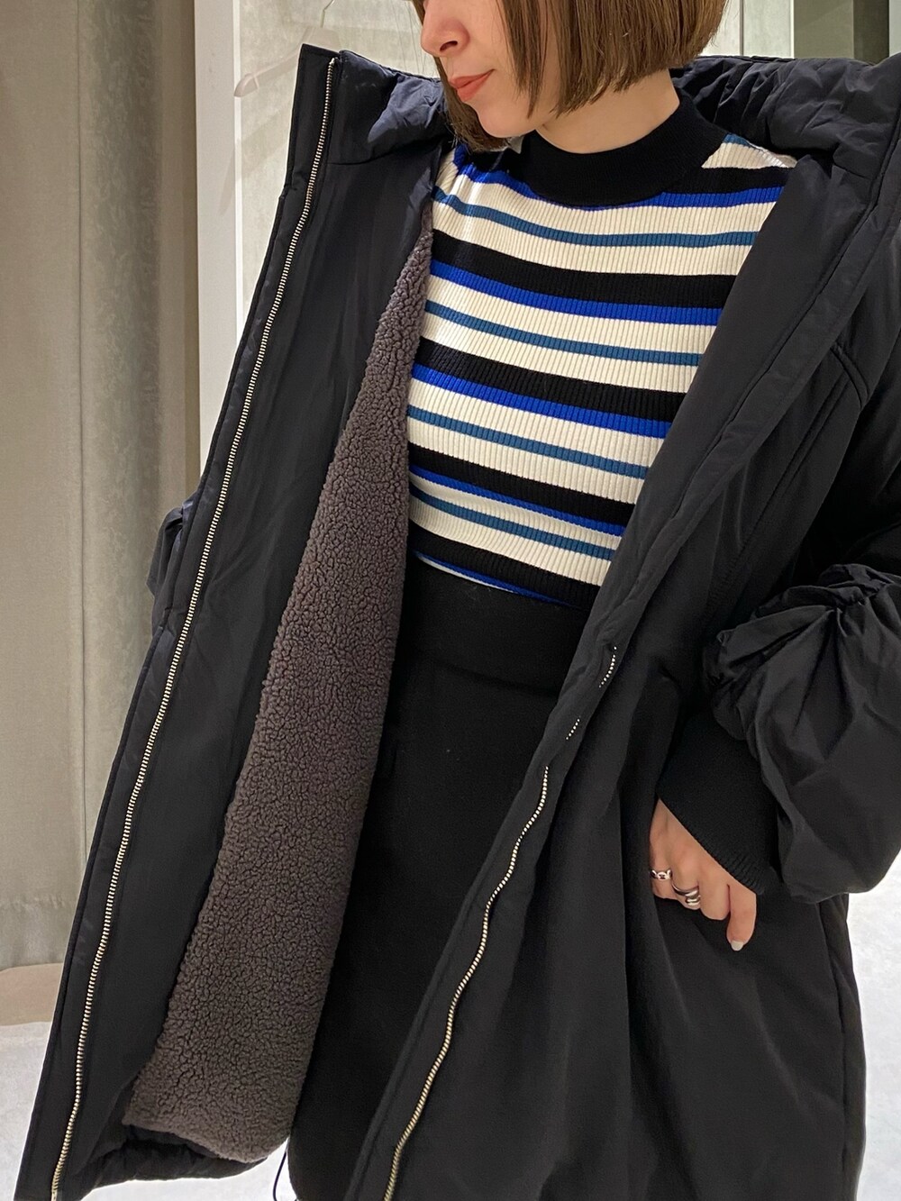 ブラック系のブルゾン、ブルー系のニット/セーター、ブラック系のスカートを着用したレディースの秋コーディネートの10枚目の写真