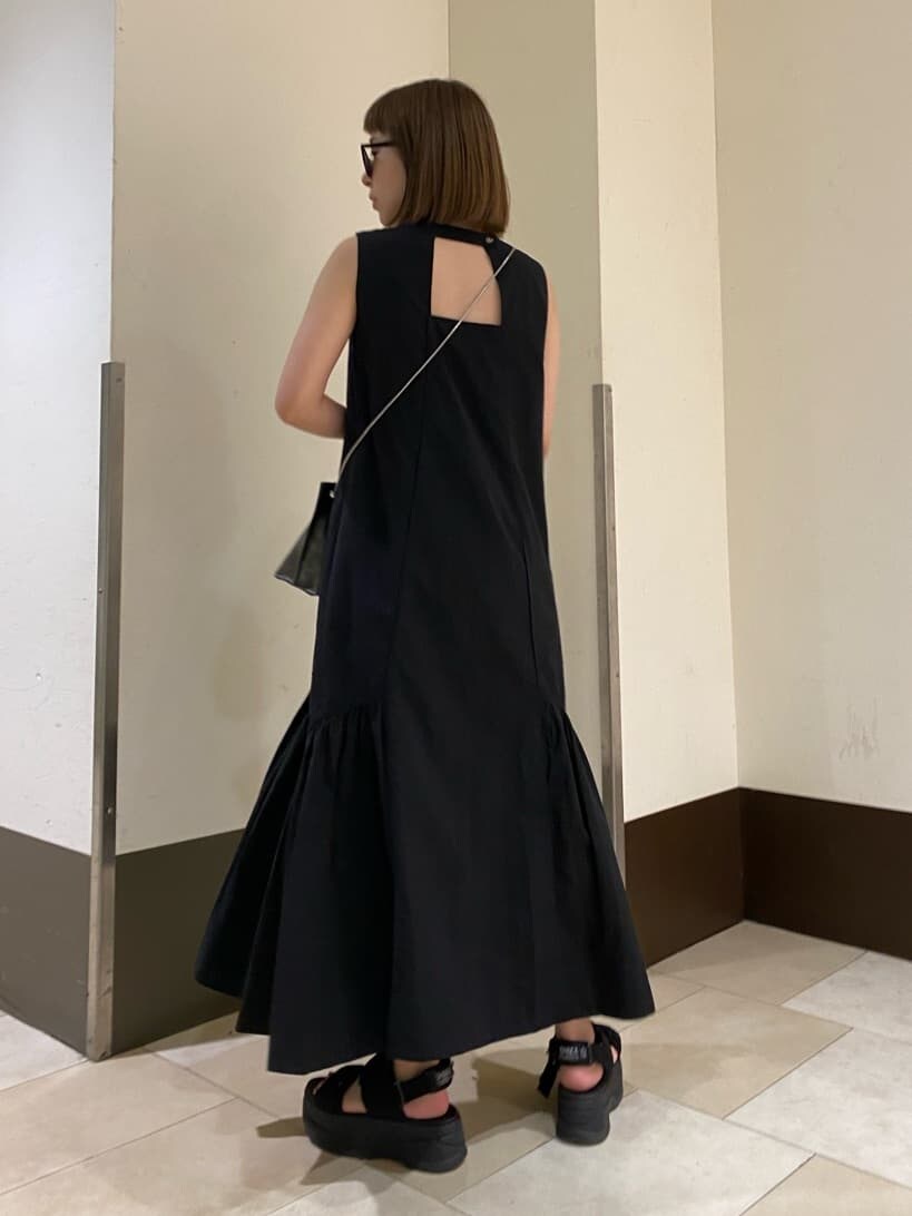 ホワイト系のサンダル、ブラック系のショルダーバッグ、ブラック系のワンピースを着用したレディースの夏コーディネートの6枚目の写真