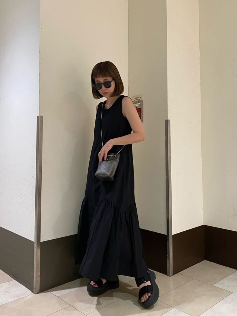 ホワイト系のサンダル、ブラック系のショルダーバッグ、ブラック系のワンピースを着用したレディースの夏コーディネートの3枚目の写真