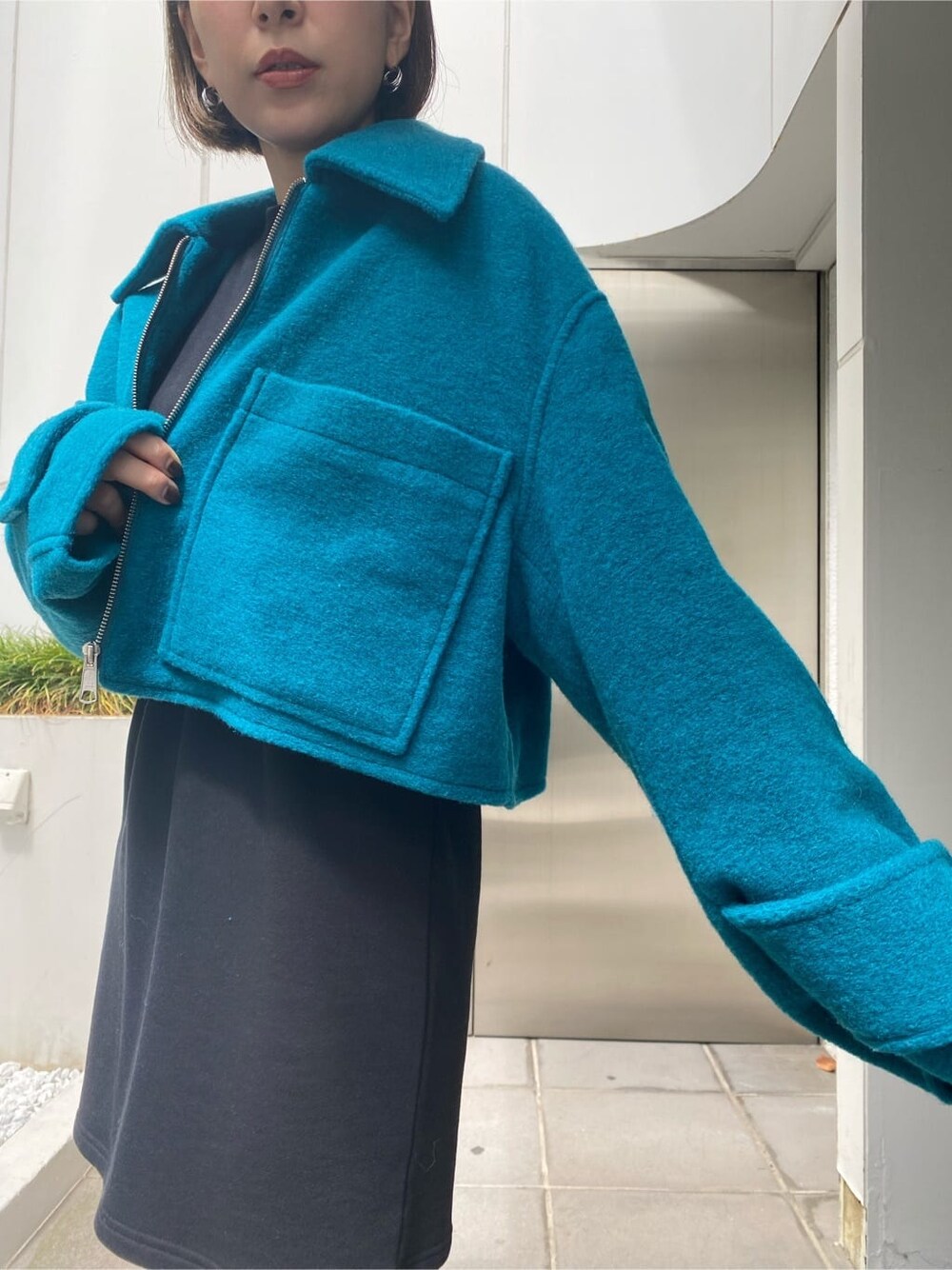 ブラック系のワンピース、ブルー系のブルゾンを着用したレディースの秋コーディネートの6枚目の写真