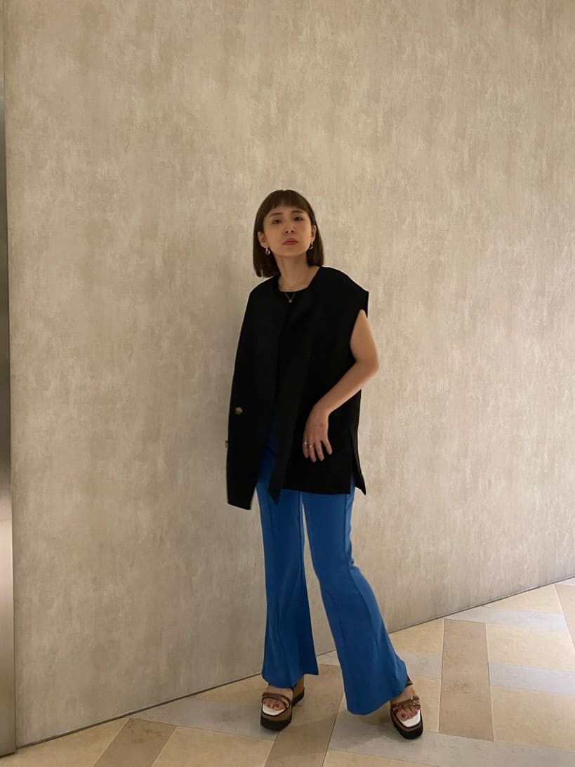 ブルー系のスラックス、ブラック系のベスト、ブラック系のタンクトップを着用したレディースの夏コーディネートの2枚目の写真