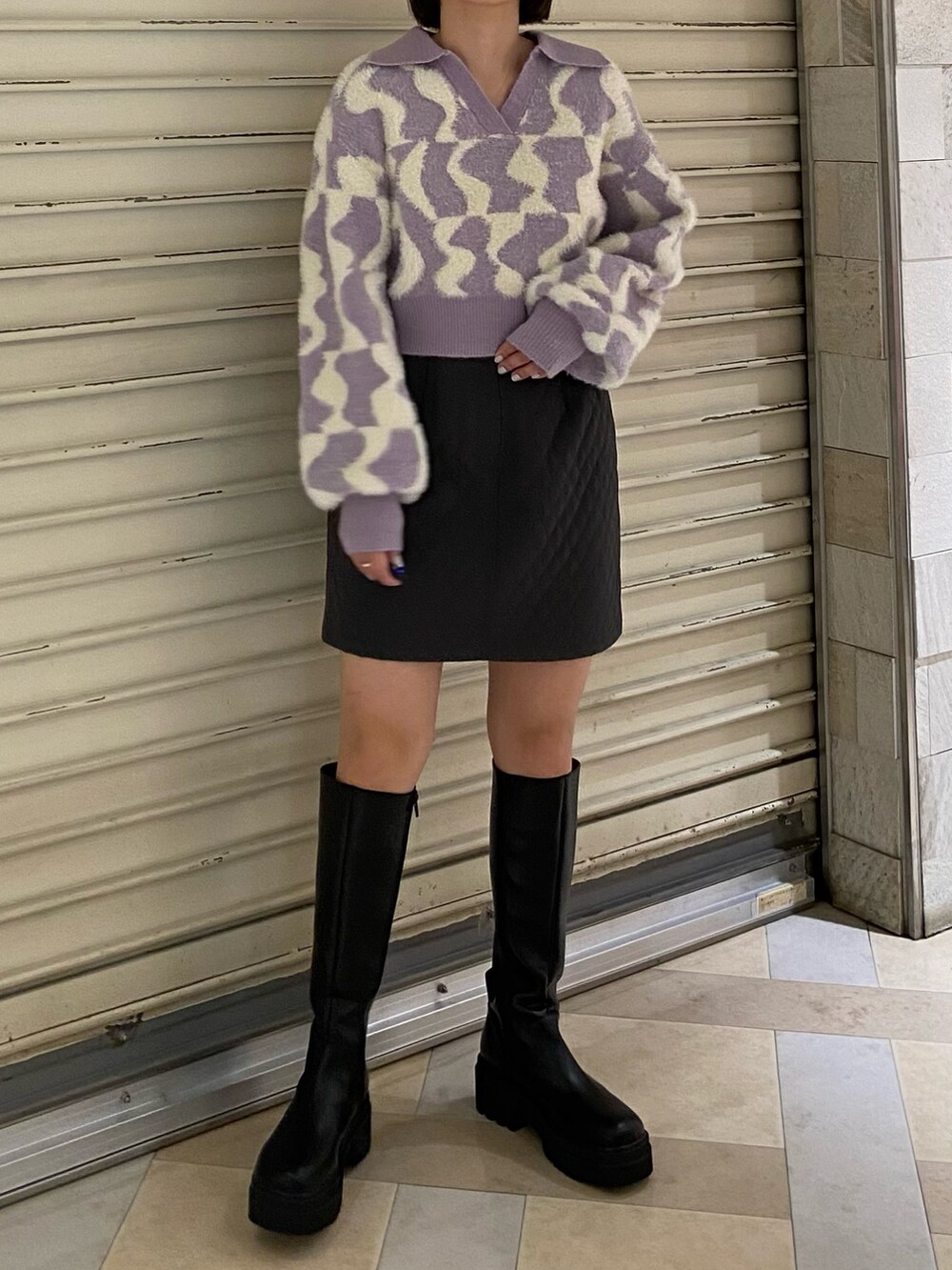 パープル系のニット/セーター、グレー系のスカート、ブラック系のブーツを着用したレディースの秋コーディネートの3枚目の写真