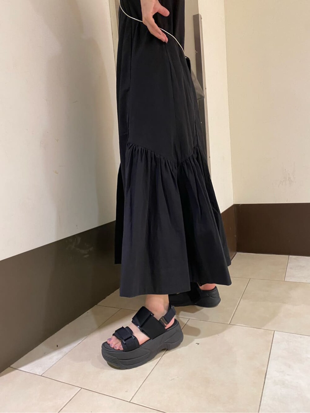 ホワイト系のサンダル、ブラック系のショルダーバッグ、ブラック系のワンピースを着用したレディースの夏コーディネートの9枚目の写真