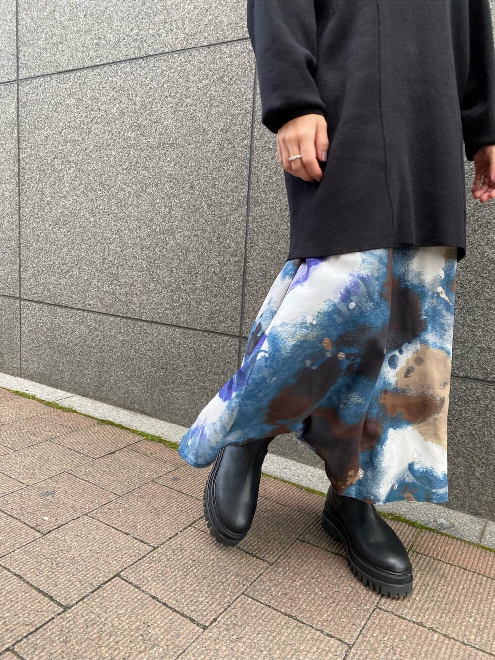 ブラック系のワンピース、ブルー系のスカート、ブラック系のブーツを着用したレディースの秋コーディネートの10枚目の写真