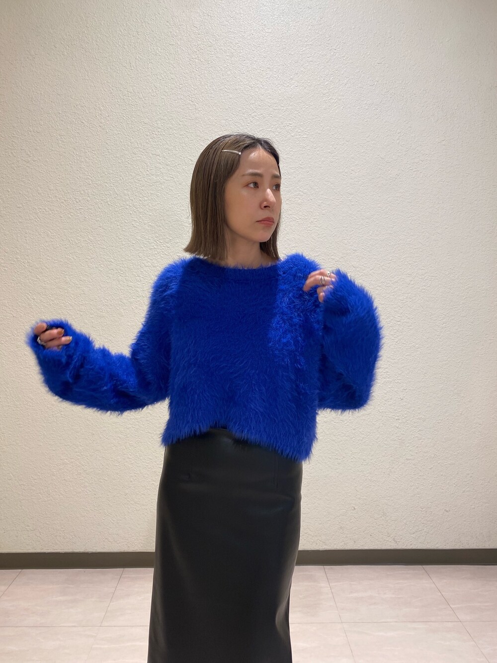 ブルー系のニット/セーター、ブラック系のスカートを着用したレディースの秋コーディネートの4枚目の写真