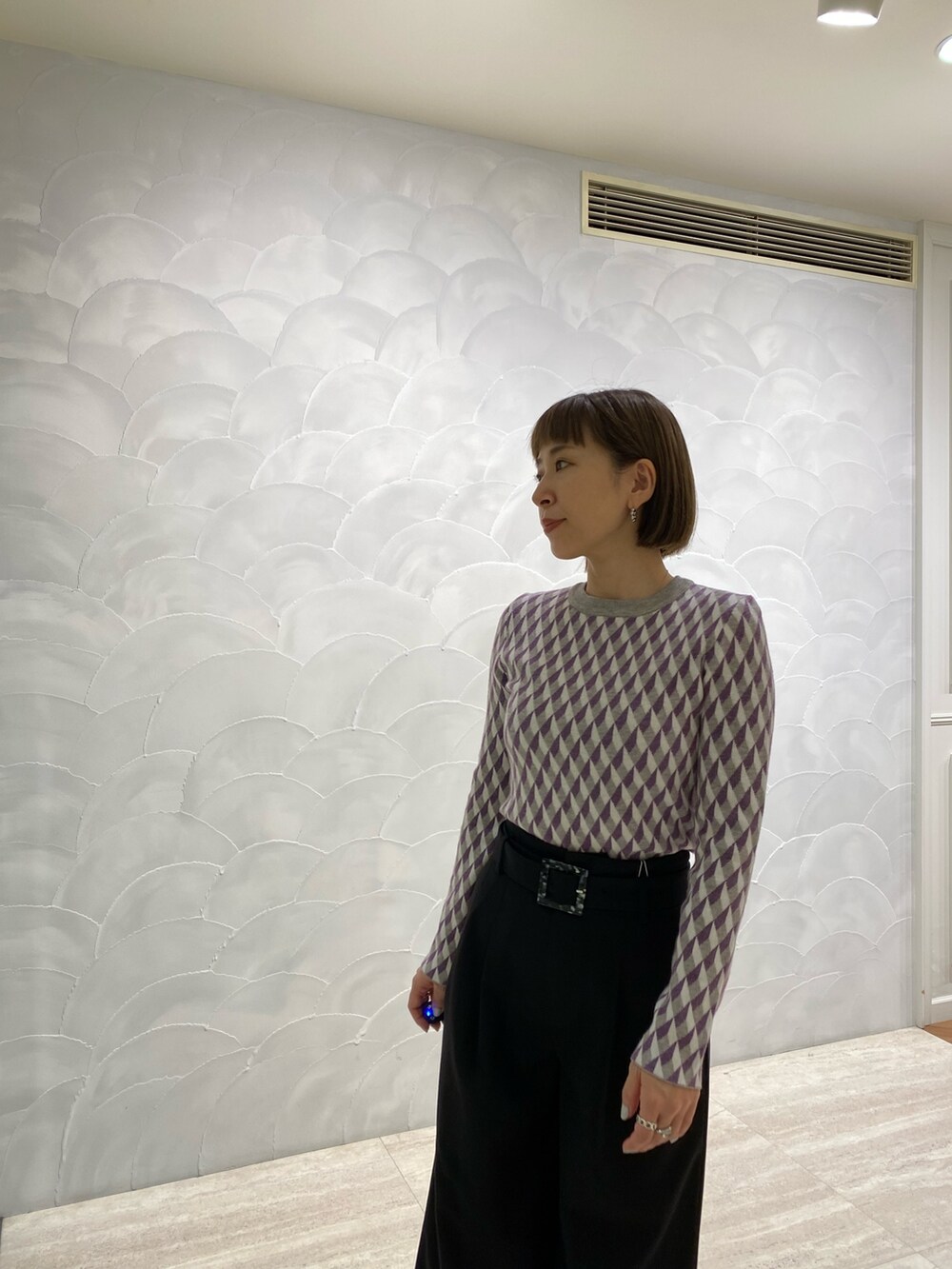 ブラック系のニット/セーター、ブラック系のスラックス、ブラック系のブーツを着用したレディースの冬コーディネートの5枚目の写真