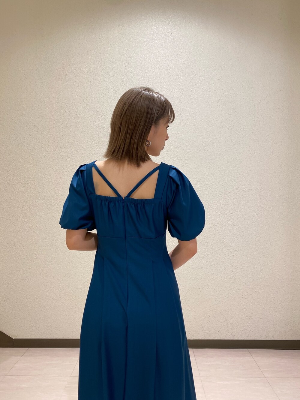 ブルー系のワンピース、ブラック系のサンダル、ブラック系のハンドバッグを着用したレディースの夏コーディネートの4枚目の写真