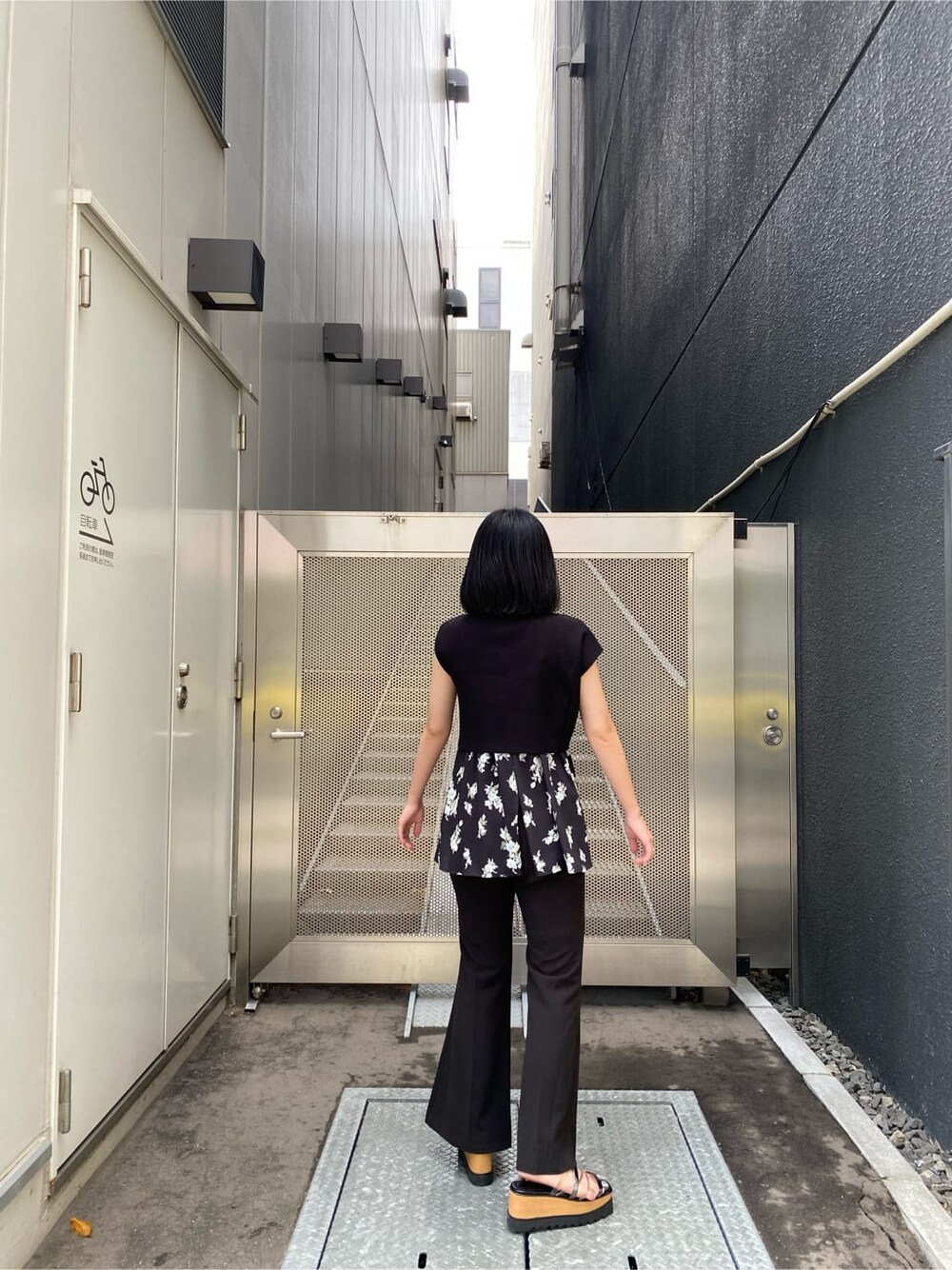 ブラック系のサンダル、ブラック系のスラックス、ブラック系のニット/セーターを着用したレディースの夏コーディネートの3枚目の写真