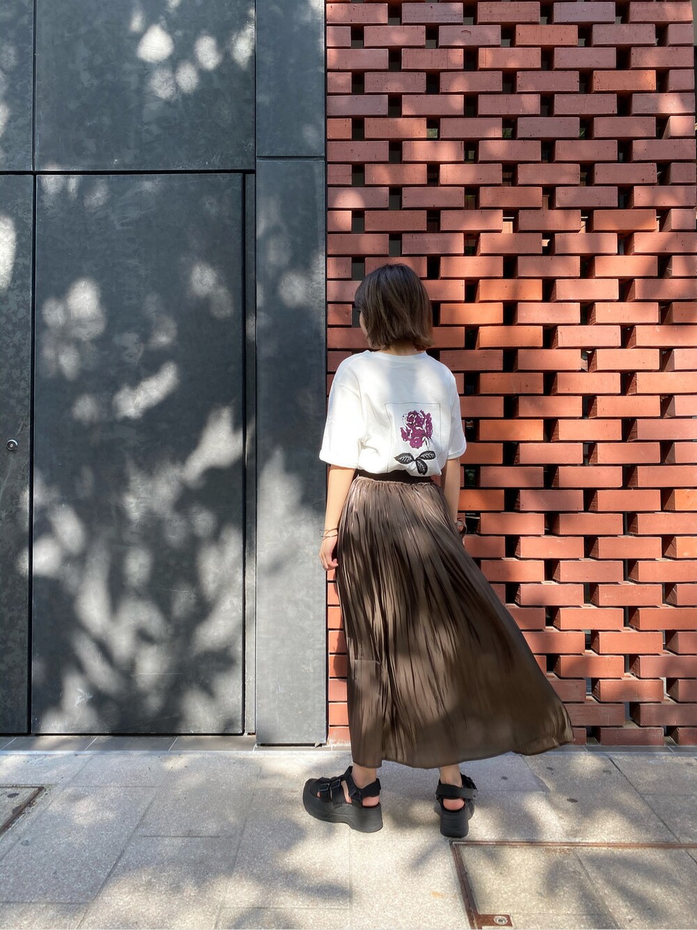 ホワイト系のTシャツ/カットソー、ブラウン系のスカート、ブラック系のサンダルを着用したレディースの夏コーディネートの2枚目の写真