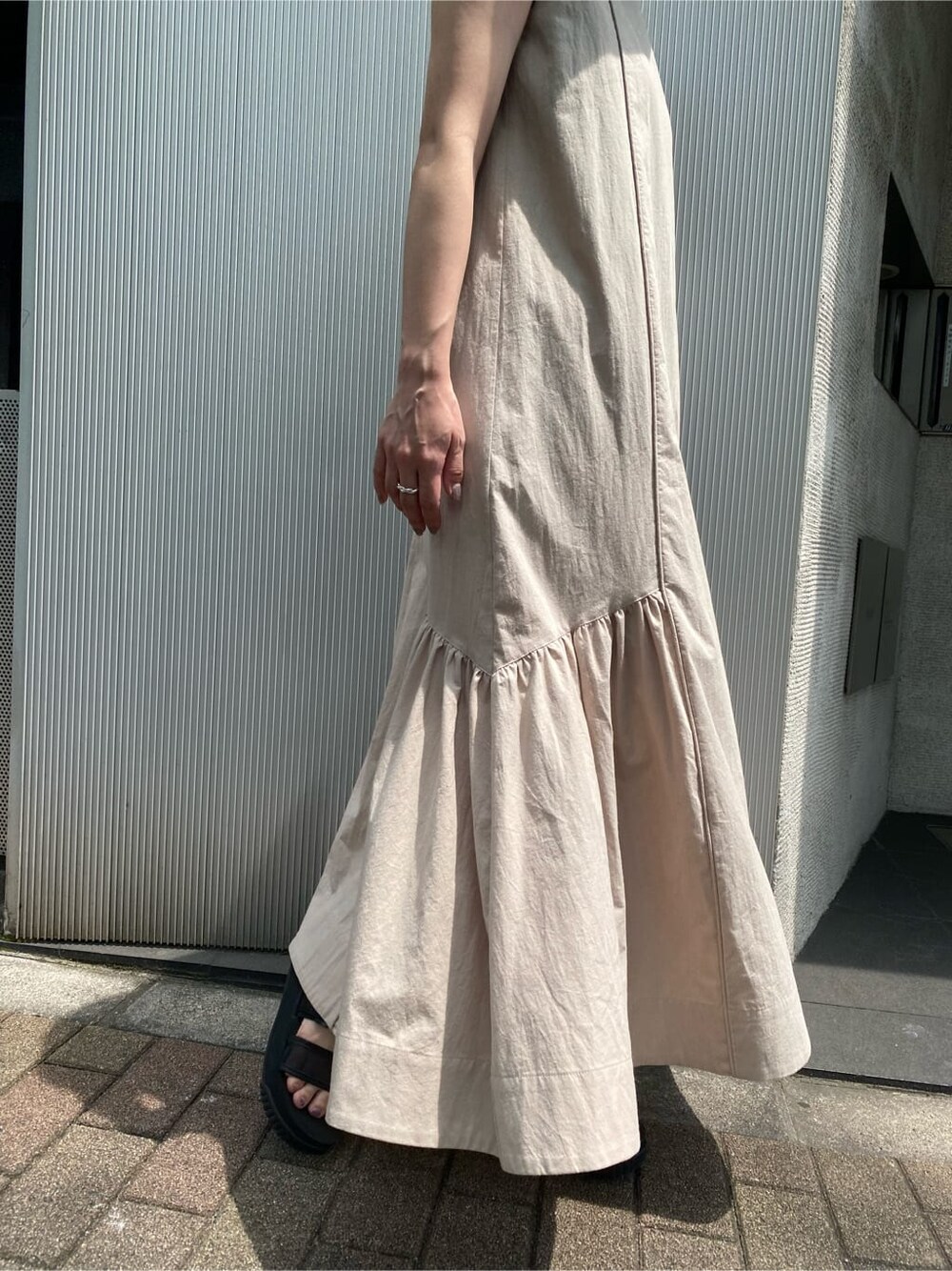 ベージュ系のワンピース、ブラック系のハットを着用したレディースの夏コーディネートの7枚目の写真