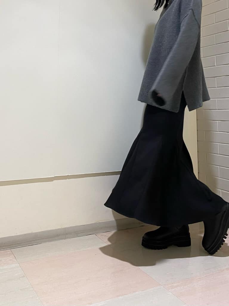 ブラック系のブーツ、グレー系のニット/セーター、ブラック系のスカートを着用したレディースの冬コーディネートの4枚目の写真