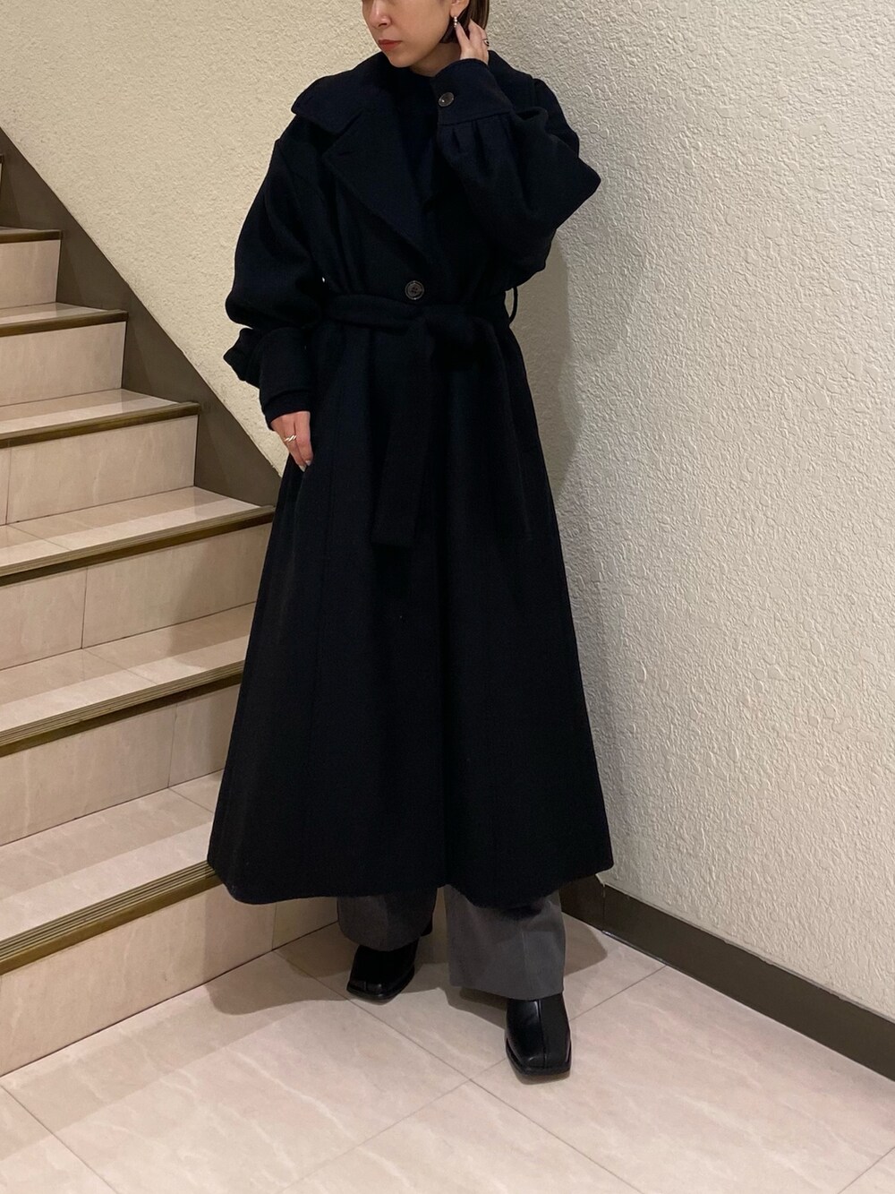 ブラック系のダウンジャケット/コート、パープル系のニット/セーター、グレー系のスラックスを着用したレディースの秋コーディネートの3枚目の写真