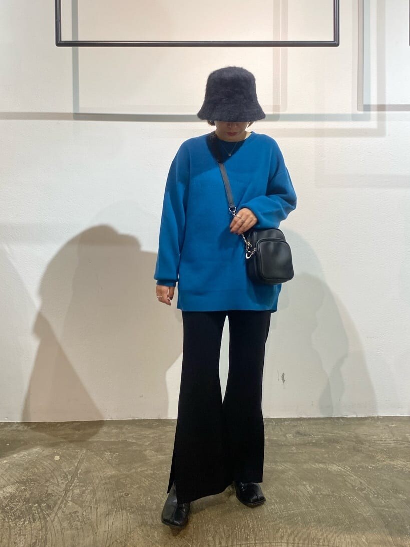 ブラック系のスラックス、ブルー系のニット/セーター、ブラック系のショルダーバッグを着用したレディースの秋コーディネートの4枚目の写真
