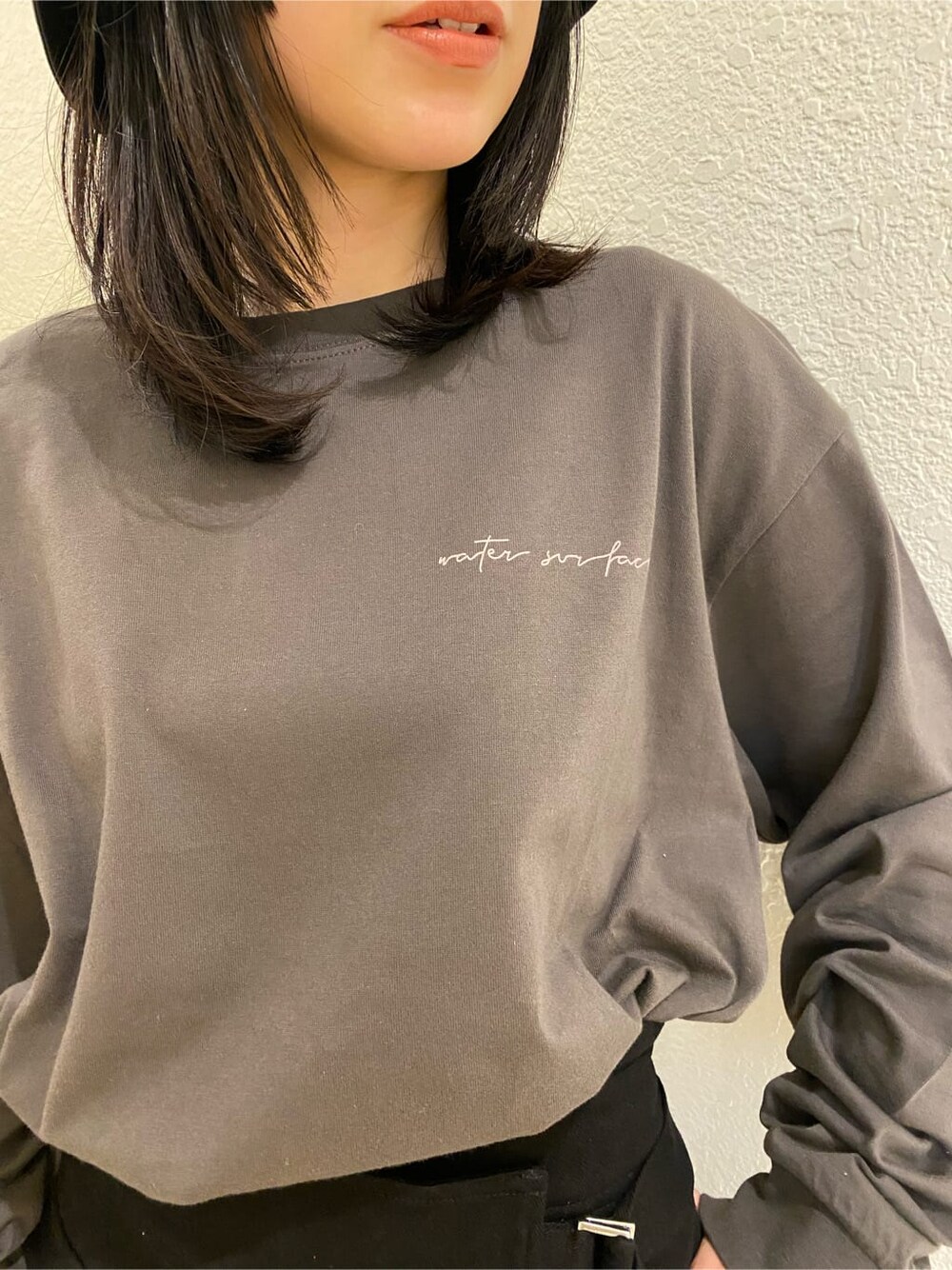 ブラック系のスカート、ブラック系のサンダル、グレー系のTシャツ/カットソーを着用したレディースの春コーディネートの5枚目の写真