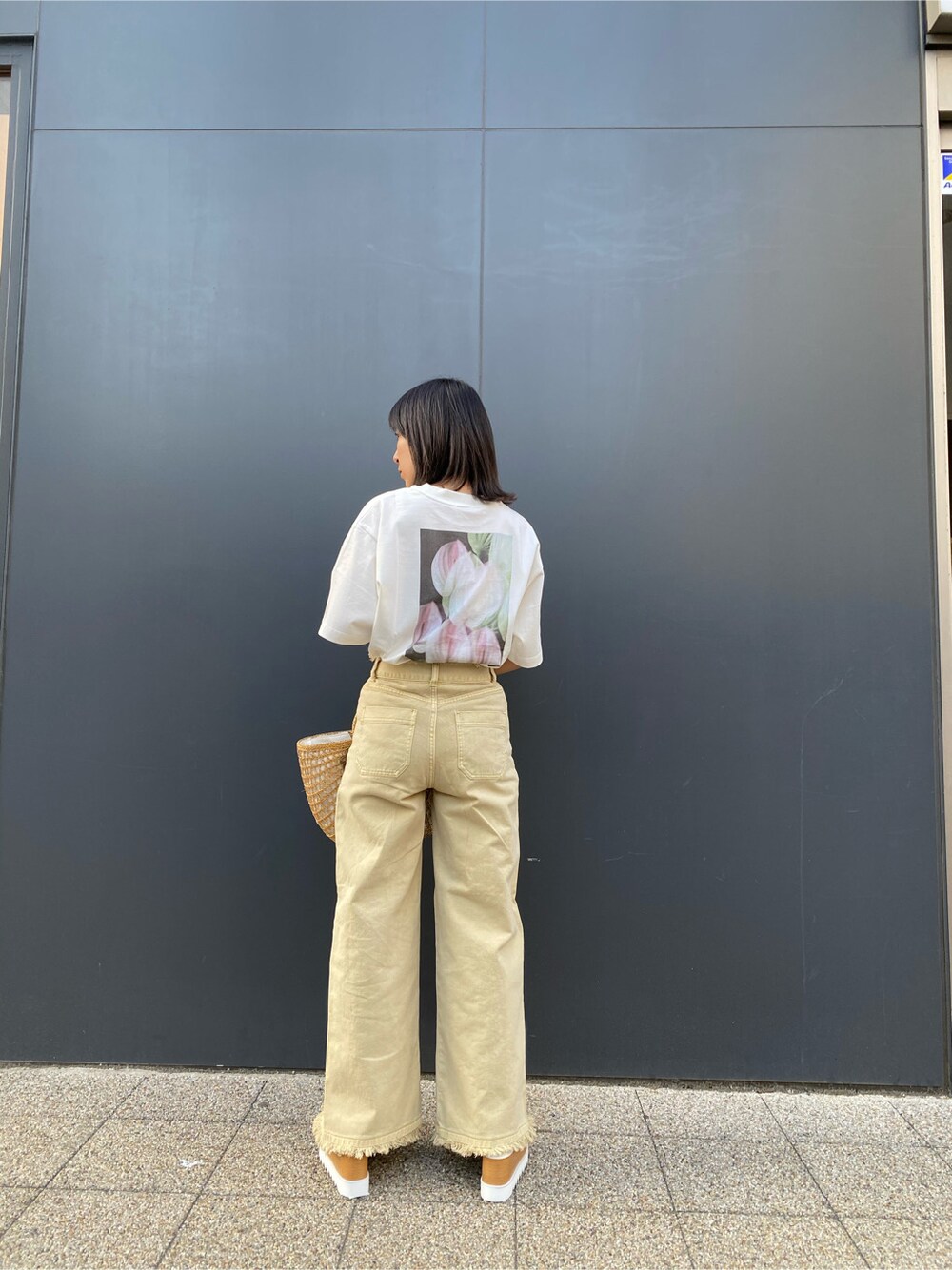 ベージュ系のかごバッグ、イエロー系のその他パンツ、ホワイト系のTシャツ/カットソーを着用したレディースの春コーディネートの3枚目の写真